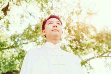 Yakışıklı adam Thai Chi yapıyor.