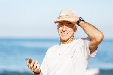 Erkek runner mobil akıllı telefonunu açık havada duran ile