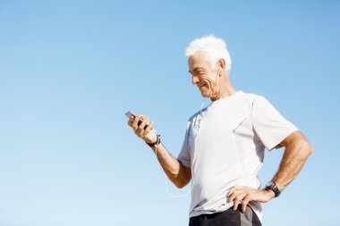 Erkek runner mobil akıllı telefonunu açık havada duran ile