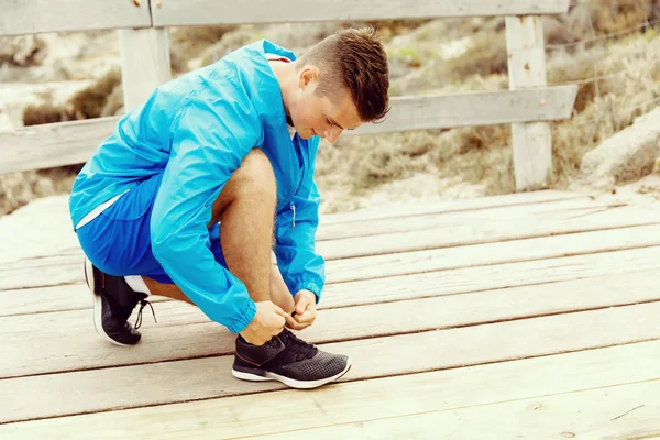 Corredor cadarços seus sapatos e se prepara para correr — Fotografia de Stock