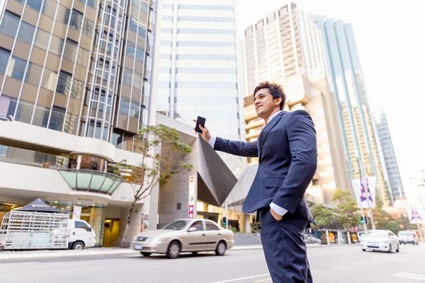 Businessman catching taxi in city — Stock Photo, Image