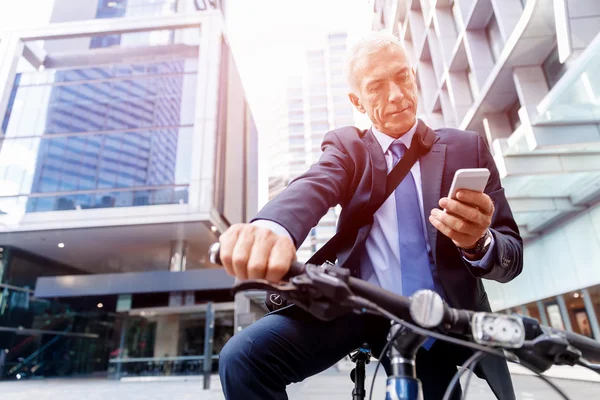 Successful businessman riding bicycle — Stock Photo, Image