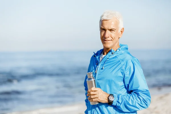 Homem confiante segurando garrafa com água — Fotografia de Stock