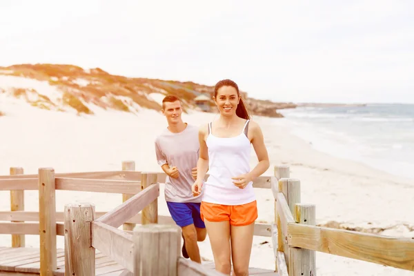 Biegaczy. Młoda para na plaży — Zdjęcie stockowe