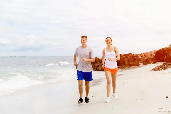 Läufer. junges Paar läuft am Strand — Stockfoto