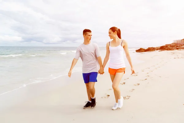 Corredores. Jovem casal correndo na praia — Fotografia de Stock