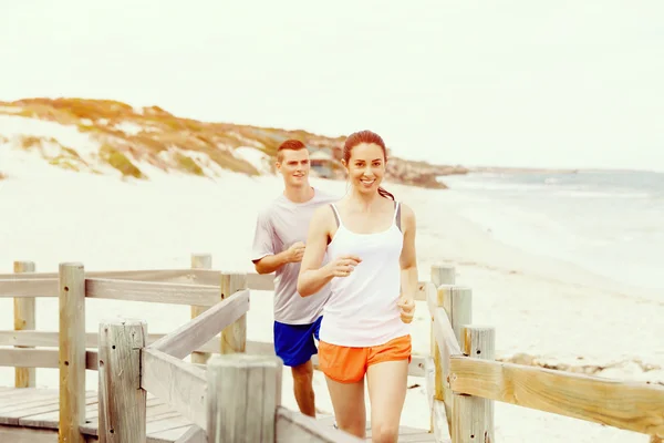 Runners. Young couple running on beach — Stock Photo, Image