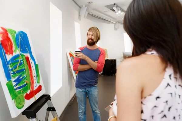 Jóvenes de pie en una galería contemplando obras de arte —  Fotos de Stock