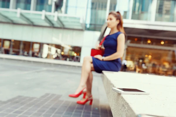 Mulher de negócios em segundo plano com um telefone inteligente — Fotografia de Stock