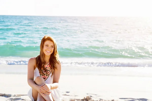 Jovem mulher sentada na praia — Fotografia de Stock