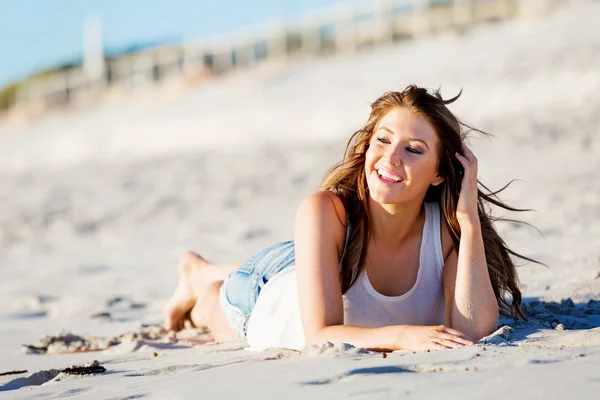 Mujer joven relajándose en la playa — Foto de Stock