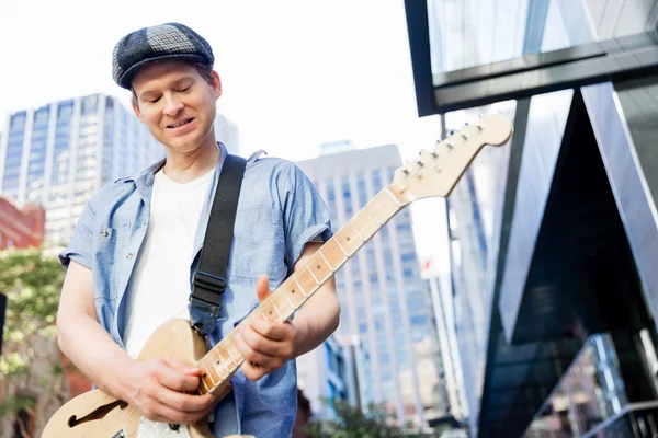 Jovem músico com guitarra na cidade — Fotografia de Stock