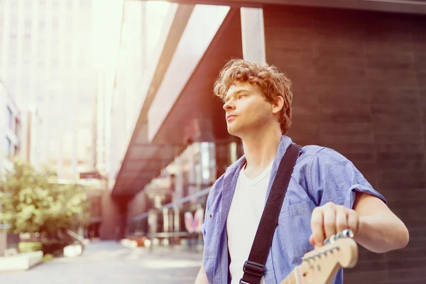 Young musician with guitar in city — Stock Photo, Image