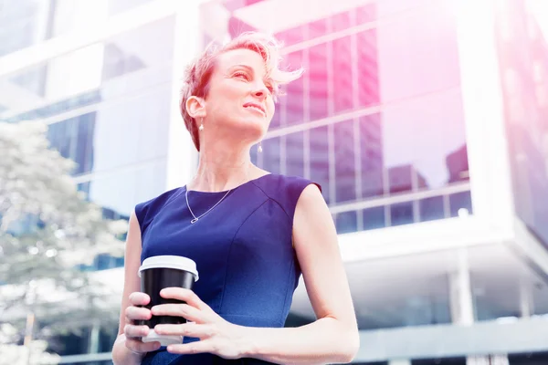 Businesswoman with coffee in a city — Stock Photo, Image