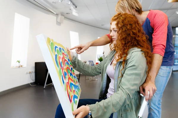 Young caucasian couple standing in a gallery and contemplating artwork — Stock Photo, Image