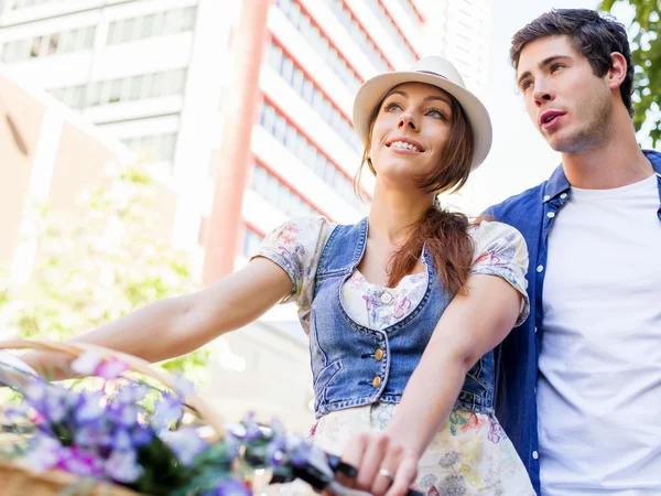 Счастливая пара в городе на велосипеде — стоковое фото