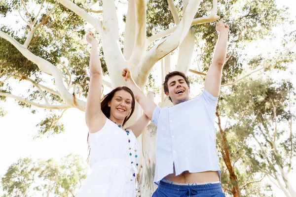 Young couple in the park celebrating — Stock Photo, Image