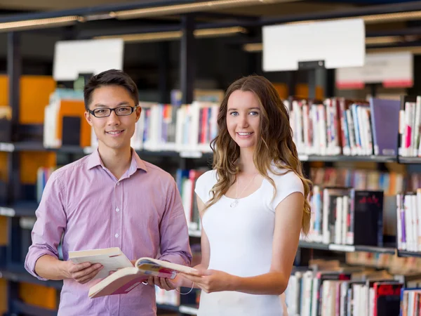 Два молодых студента в библиотеке — стоковое фото
