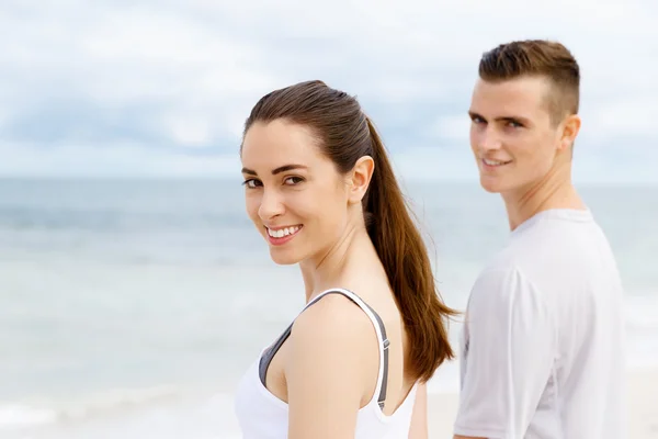 Jong koppel op zoek doordachte terwijl staande naast elkaar op het strand — Stockfoto