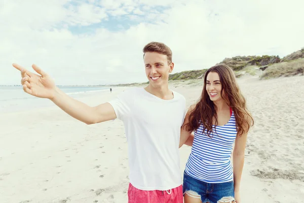 Jovem feliz e mulher casal juntos andando em uma praia — Fotografia de Stock