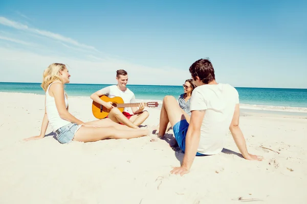 Красивые молодые люди с гитарой на пляже — стоковое фото