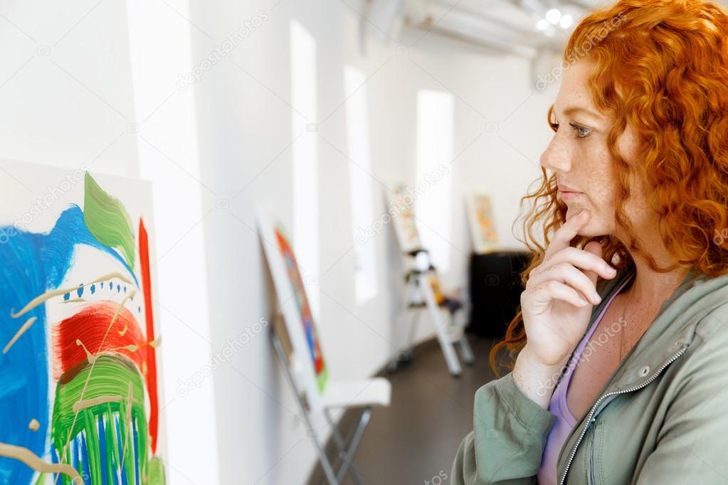 Young caucasian woman in art gallery front of  paintings