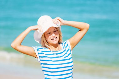 Genç bir kadın sahilde dinleniyor.