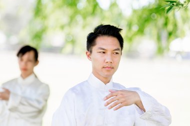 Yakışıklı adam Thai Chi yapıyor.