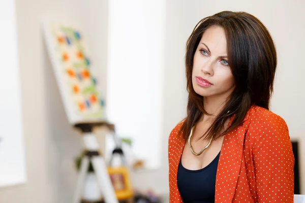 Mujer joven caucásica de pie en la galería de arte frente a las pinturas — Foto de Stock