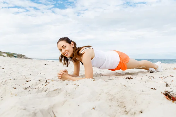 Młoda kobieta na plaży poza szkolenia — Zdjęcie stockowe