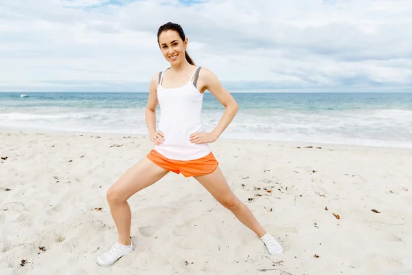 Mujer joven entrenando en la playa afuera — Foto de Stock