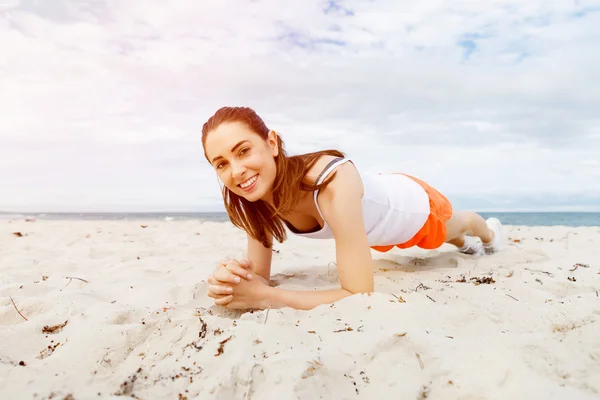 Mujer joven entrenando en la playa afuera —  Fotos de Stock