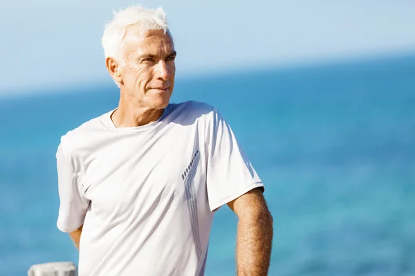 Человек, стоящий на пляже в спортивной одежде — стоковое фото