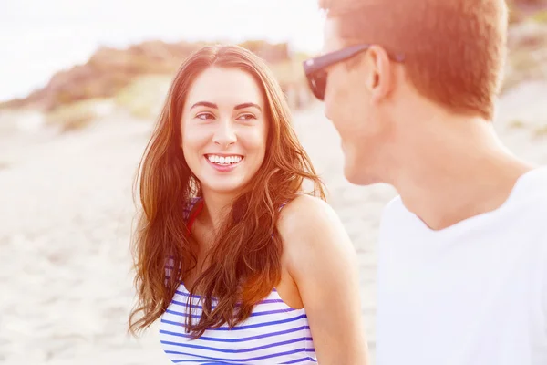 Romántica pareja joven sentada en la playa — Foto de Stock