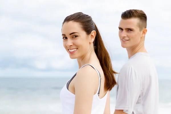 Pareja joven buscando reflexivo mientras están de pie uno al lado del otro en la playa — Foto de Stock