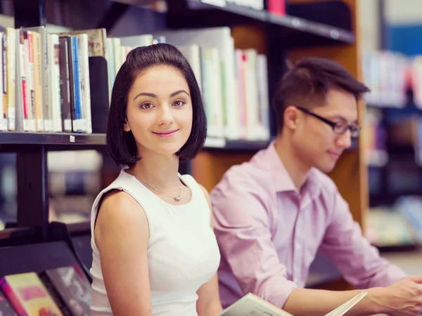 Dos jóvenes estudiantes en la biblioteca —  Fotos de Stock