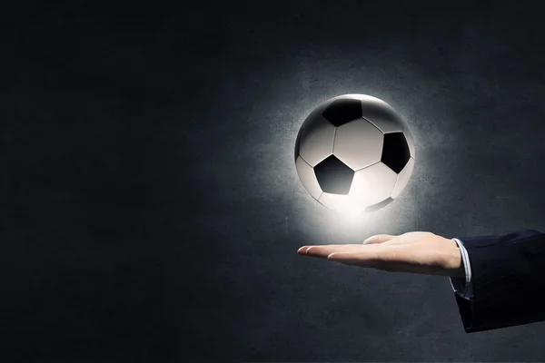 Bola de futebol na palma da mão — Fotografia de Stock