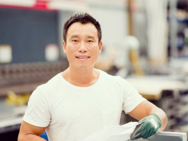 Asian worker in production plant on the factory floor clipart