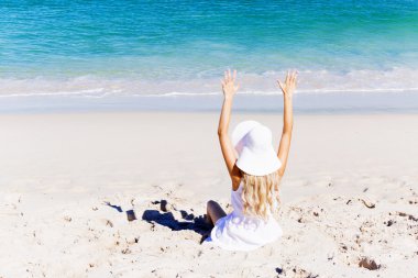 Genç bir kadın sahilde dinleniyor.