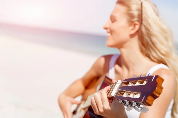 Wanita muda yang cantik bermain gitar di pantai — Stok Foto