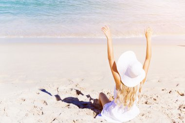 Genç bir kadın sahilde dinleniyor.