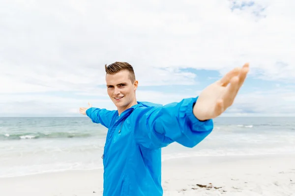 Young man in sport wear with outstretched arms — Stock Photo, Image