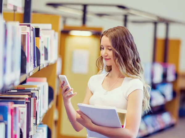 Szczęśliwy kobiet student trzymania książek w bibliotece — Zdjęcie stockowe