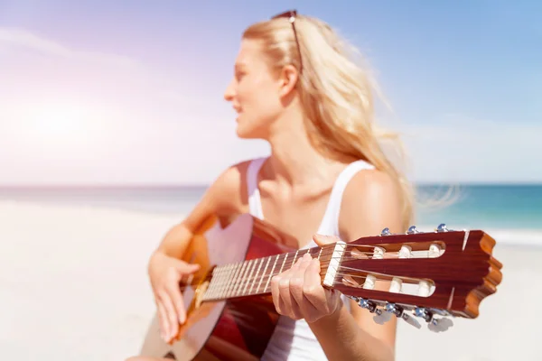 Güzel genç bir kadın sahilde gitar çalıyor. — Stok fotoğraf