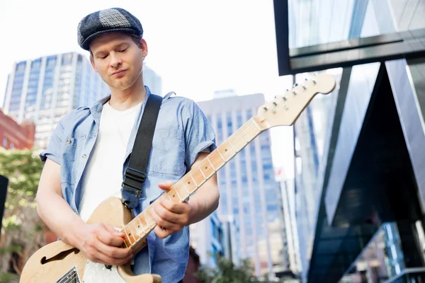 Jovem músico com guitarra na cidade — Fotografia de Stock