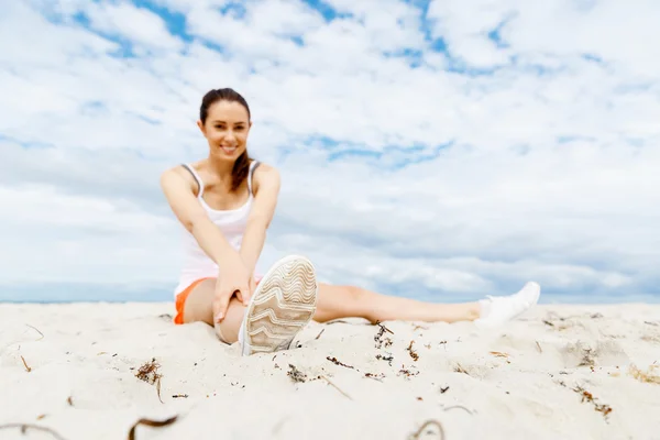 Mujer joven entrenando en la playa afuera —  Fotos de Stock