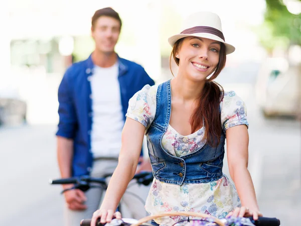 Happy couple in city with bike — Stock Photo, Image