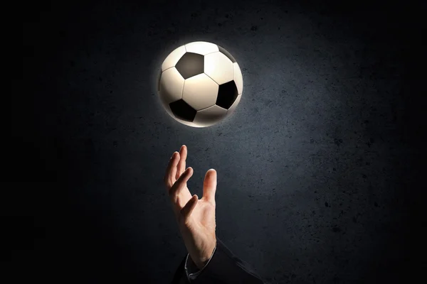 Pelota de fútbol en la palma — Foto de Stock