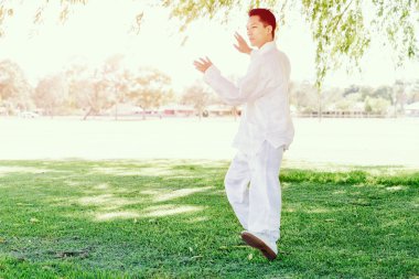 Yakışıklı adam Thai Chi yapıyor.