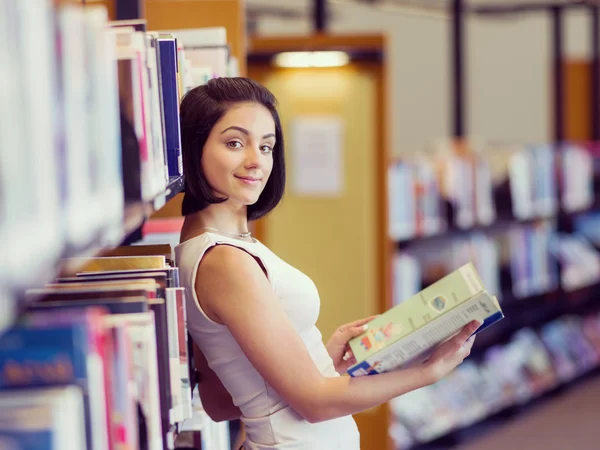 Gelukkig vrouwelijke student in de bibliotheek — Stockfoto